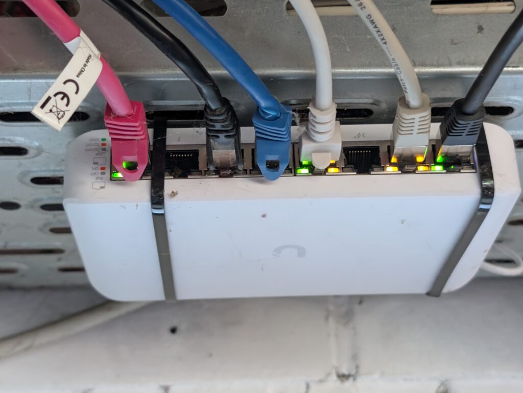 UniFi Switch Ultra (USW-Ultra-60W) mit angeschlossenen Netzwerkkabeln in der Garage